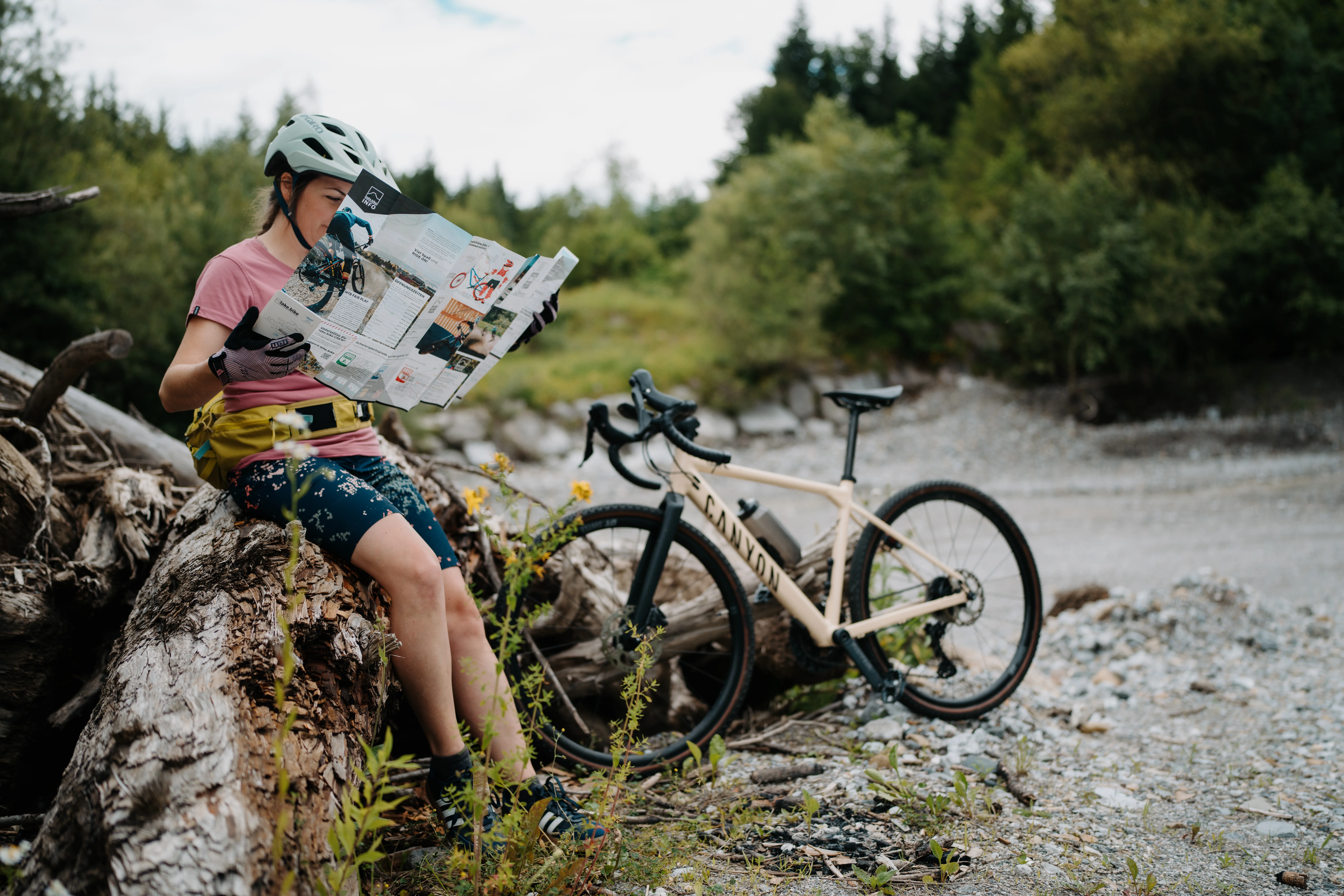 Radfahrerin klappt s-format Bikemap auf