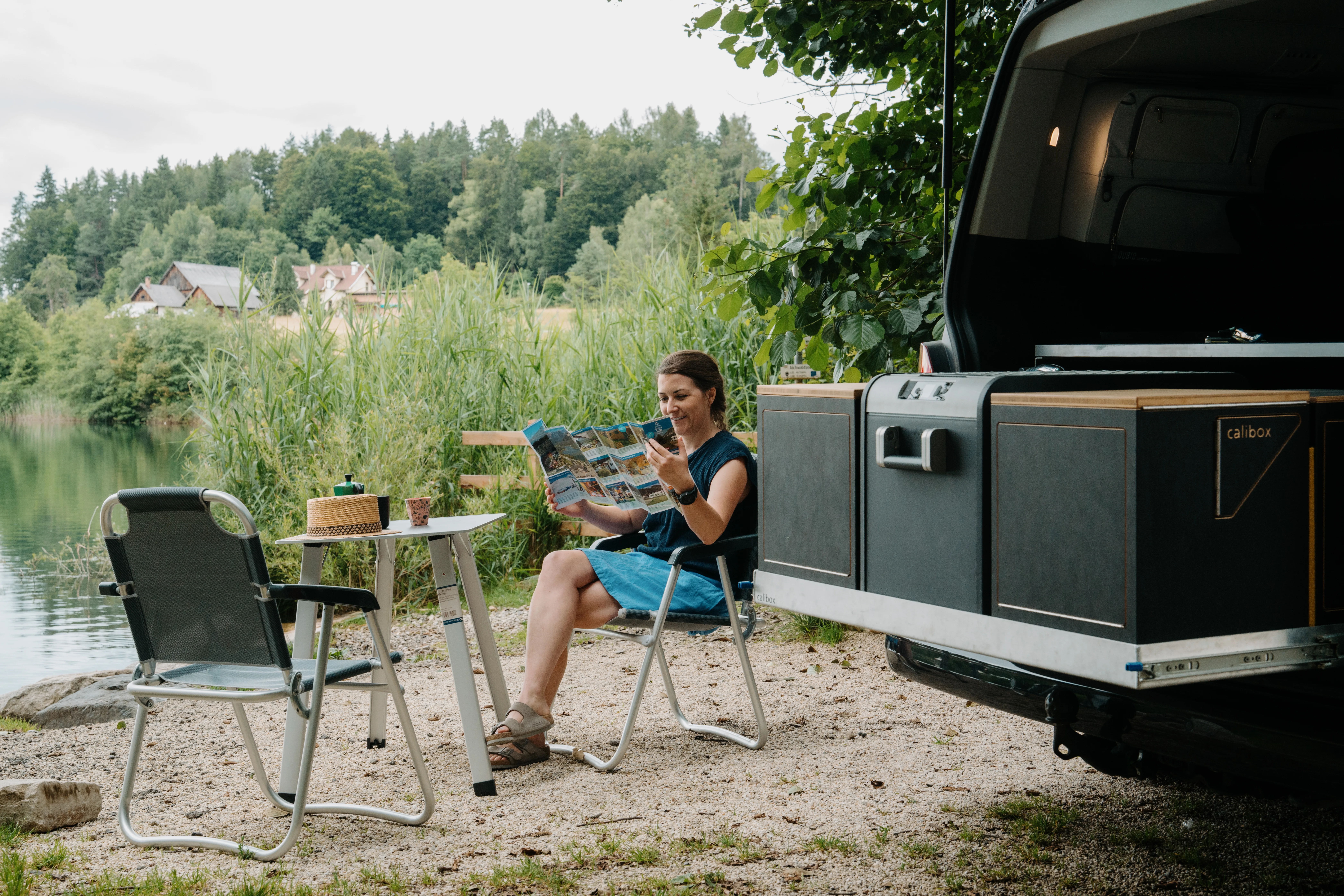 Campingbus - Dame klappt Faltkarte auf