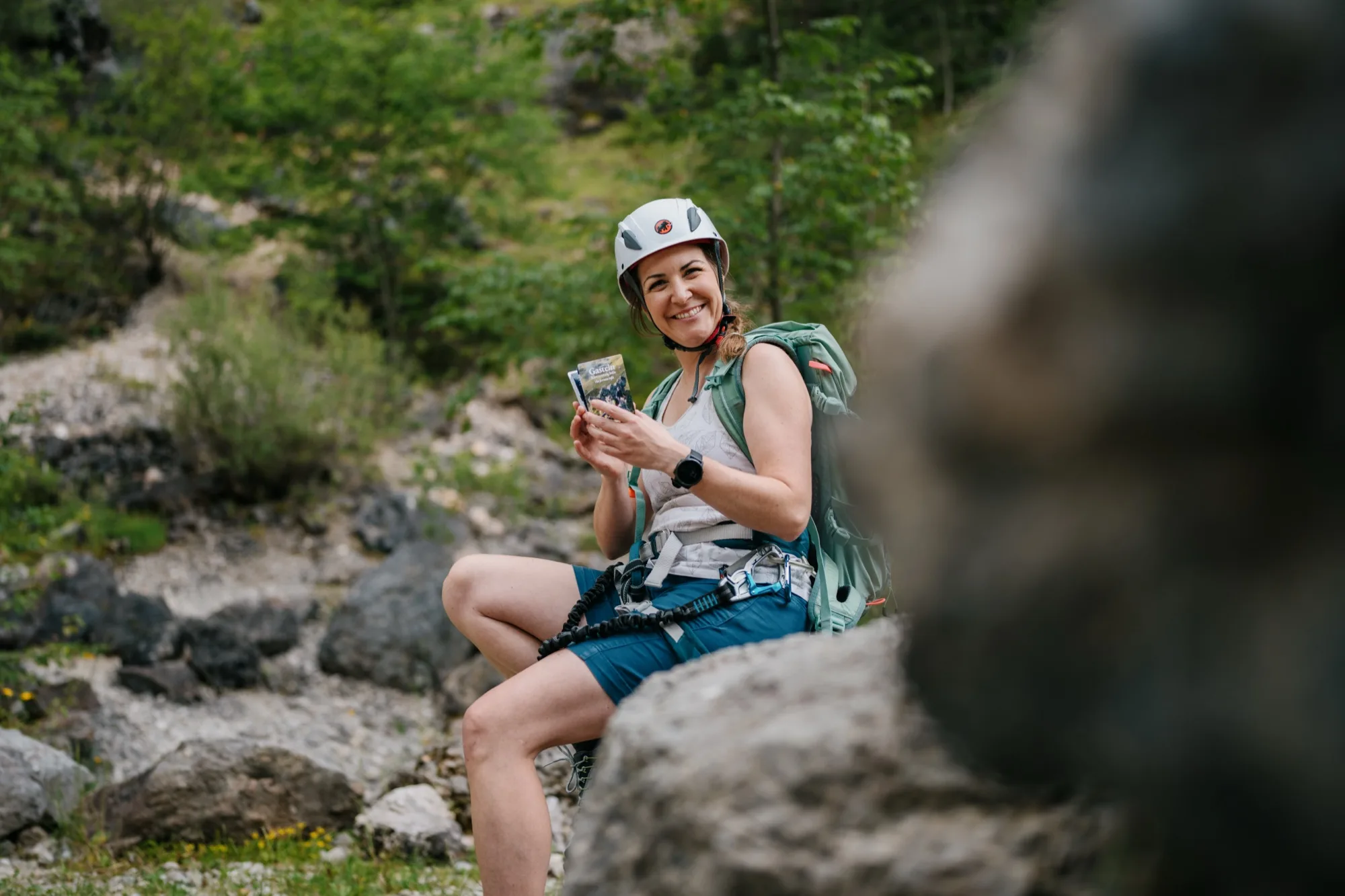 Klettersteiggeherin mit s-format Pocketguide in der Hand am Klettersteig Gasteinertal – kompakter Klettersteigführer