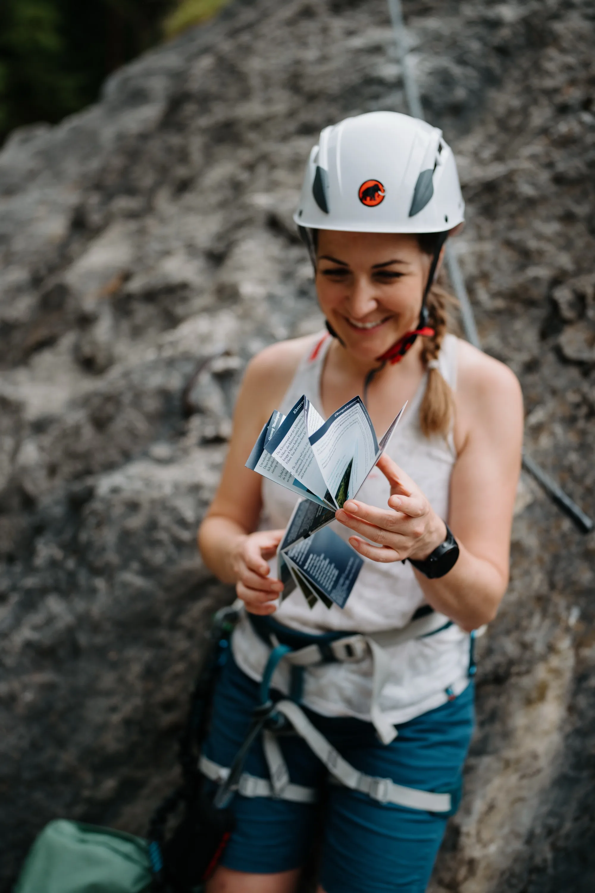 Kletterin faltet Klettersteig-Guide Gasteinertal zusammen – praktische Leporellofalzung der Twin-Card am Klettersteig